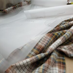 sewing pattern overlayed on brown checkered fabric